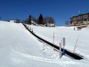 Übungspiste mit Förderband an der Bergstation der Seilbahn